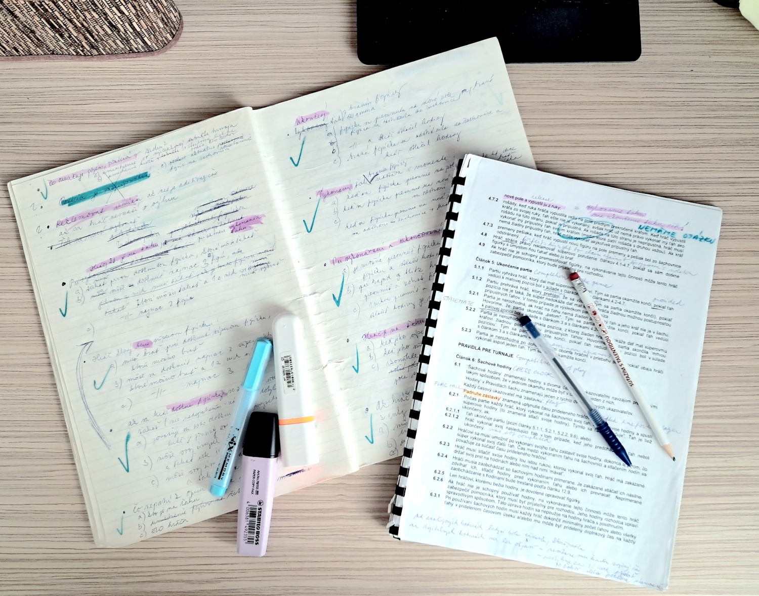 otvorený zošit, do ktorého sa píšu testové otázky a otvorené pravidlá šachu FIDE