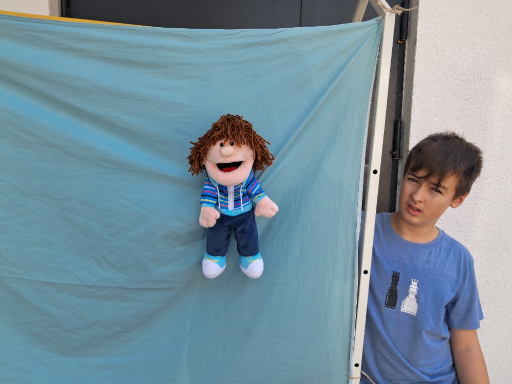 bábka Patrik Pat pred modrou plachtou